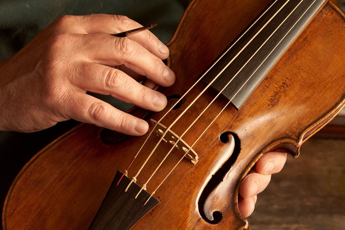 Fary re-touching the varnish to a baroque violin